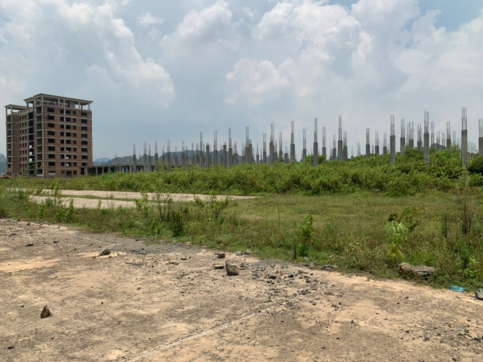 Cạnh nhà điều hành 9 tầng là khu nhà chức năng đã được đổ móng kiên cố với hàng chục trụ cột xi măng, lõi thép dang dở. Sau nhiều năm thi công đình trệ, những lõi sắt thép vẫn phơi nắng, phơi sương mà không được bảo vệ.