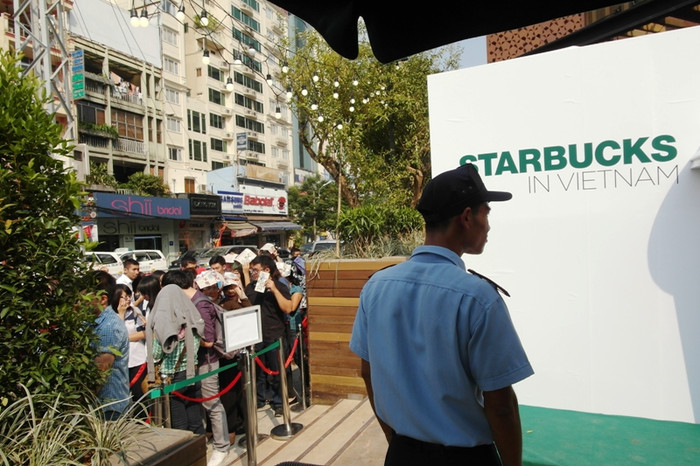 Trong khi đó, một bảo vệ vẫn lạnh lùng đứng trong bóng mát nhìn ra đám đông đau khổ dưới trời nắng gắt. Những vị khách "may mắn" vào được bên trong uống cà phê. Khung cảnh thật lộn xộn, thiếu mất không gian lãng mạn đúng với "gu" thưởng thức cà phê của người Sài Gòn. Trong khi đó, một bảo vệ vẫn lạnh lùng đứng trong bóng mát nhìn ra đám đông đau khổ dưới trời nắng gắt. Những vị khách "may mắn" vào được bên trong uống cà phê. Khung cảnh thật lộn xộn, thiếu mất không gian lãng mạn đúng với "gu" thưởng thức cà phê của người Sài Gòn.