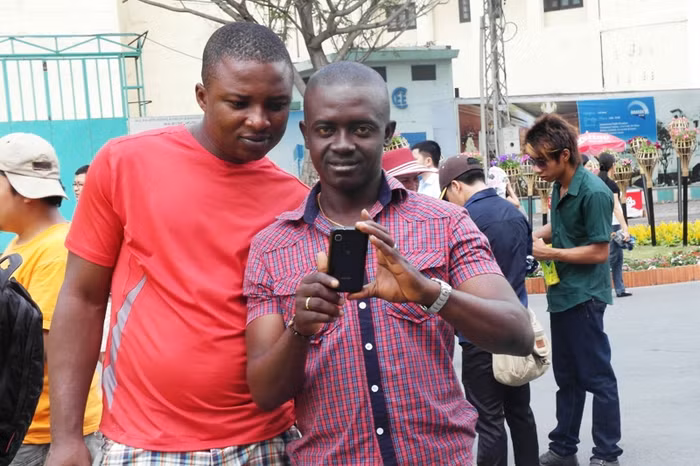 Hai thanh niên người Marốc này thích thú dùng điện thoại ghi lại những hình ảnh ấm áp ngày xuân của Việt Nam.