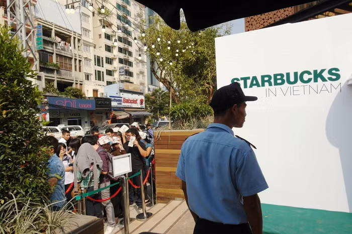 Trong khi đó, một bảo vệ vẫn lạnh lùng đứng trong bóng mát nhìn ra đám đông đau khổ dưới trời nắng gắt. Những vị khách "may mắn" vào được bên trong uống cà phê. Khung cảnh thật lộn xộn, thiếu mất không gian lãng mạn đúng với "gu" thưởng thức cà phê của người Sài Gòn.