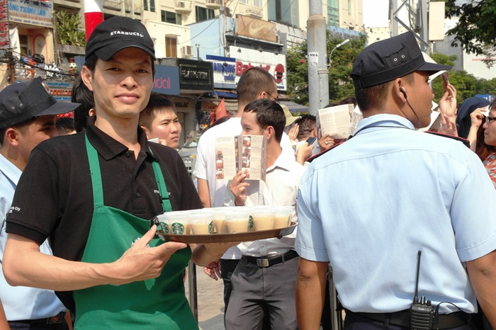 Một nhân viên Starbucks bưng những cốc cà phê sữa bé tí ra "miễn phí" cho các "thượng đế". Một nhân viên Starbucks bưng những cốc cà phê sữa bé tí ra "miễn phí" cho các "thượng đế".