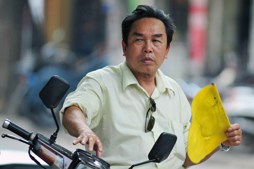 10h sáng không khí nóng bắt đầu lan tỏa, người lái xe ôm ven đường đã chuẩn bị sẵn quạt tay.