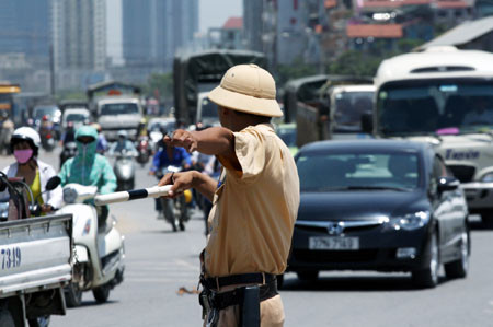 Giữa dòng phương tiện đông đúc, các chiến sĩ CSGT vẫn chỉ dẫn người tham gia giao thông đi đúng làn đường. Ảnh: Tiến Nguyên/ Dân trí.