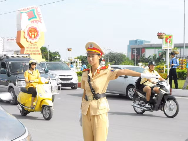 Nữ cảnh sát giao thông điều khiển các phương tiện giao thông dịp đại lễ 1000 năm Thăng Long – Hà Nội. Ảnh: Sỹ Lực/ Dân Việt.