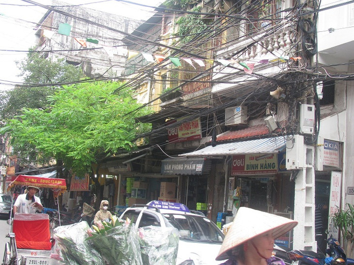 Dây điện, dây cáp tủa ra từ các cột điện và kéo dài trên phố Hàng Cân. Dây điện, dây cáp tủa ra từ các cột điện và kéo dài trên phố Hàng Cân.