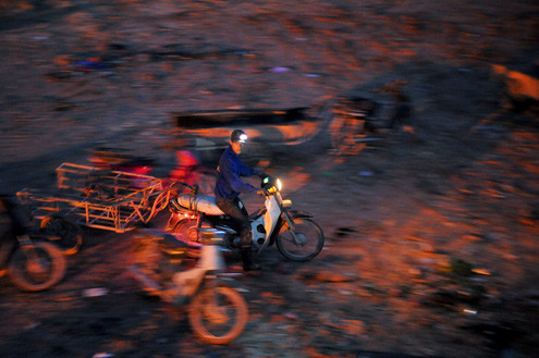 Bắt đầu từ 3h sáng những người tìm kiếm phế liệu lại đi xe máy kéo theo một chiếc xe để thồ hàng đến tập kết tại bãi rác bắt đầu công việc. Bắt đầu từ 3h sáng những người tìm kiếm phế liệu lại đi xe máy kéo theo một chiếc xe để thồ hàng đến tập kết tại bãi rác bắt đầu công việc.