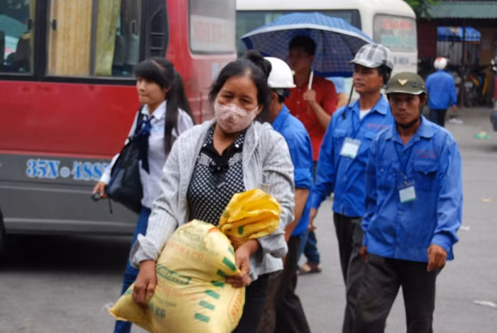 Một phụ huynh vừa bước xuống từ ô tô. Trên tay cô là 20kg gạo "chống đói" cho đợt thi Đại học, Cao đẳng dài ngày.