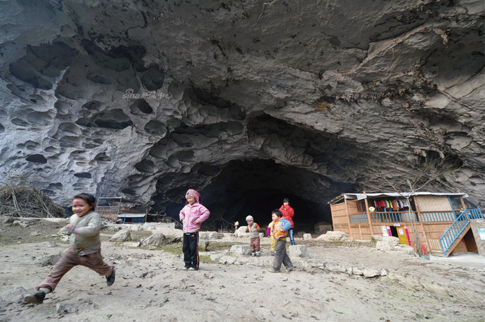 Những đứa trẻ Bố Y vui chơi trước động