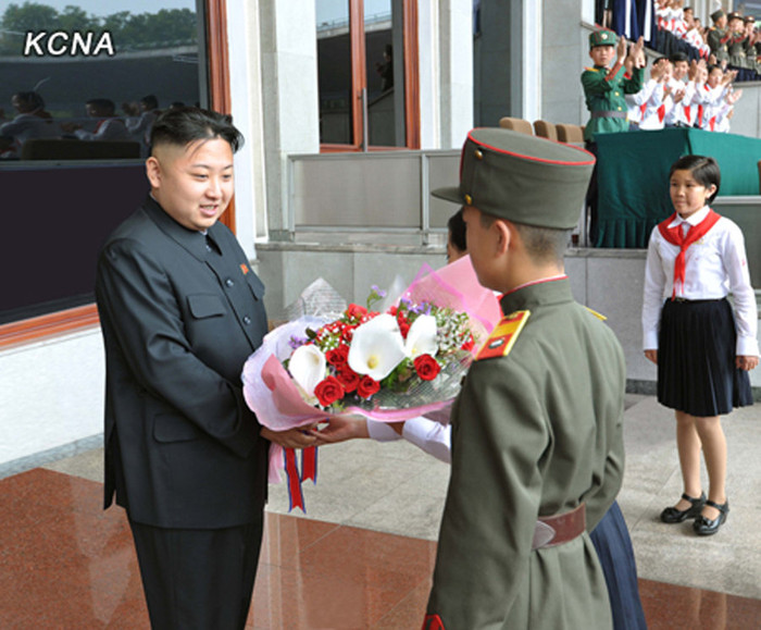 Hai thiếu niên tặng hoa nhà lãnh đạo Kim Jong-un