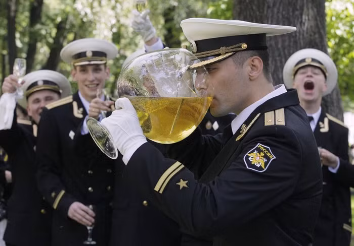 Những chiếc ly "khủng" đựng đầy rượu và nhúng thanh đoản đao tốt nghiệp của chính mình được một tân sỹ quan trẻ nâng lên uống trong tiếng reo hò cổ vũ của đồng đội