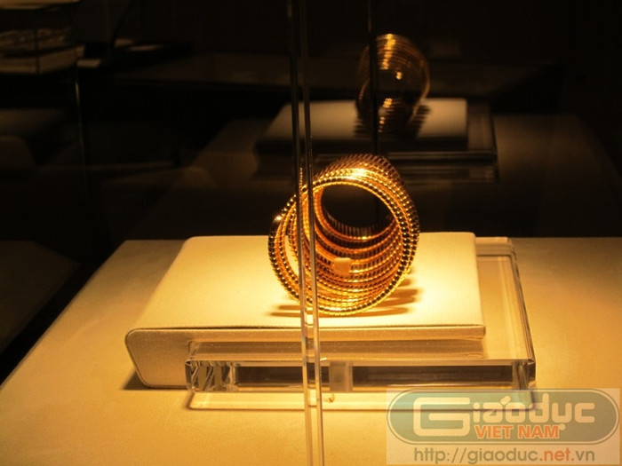 Sau lớp kính dày cộm, được khoá cẩn thận, chiếc đồng hồ được đặt trên một đế bằng nhung mềm mại... Sau lớp kính dày cộm, được khoá cẩn thận, chiếc đồng hồ được đặt trên một đế bằng nhung mềm mại...