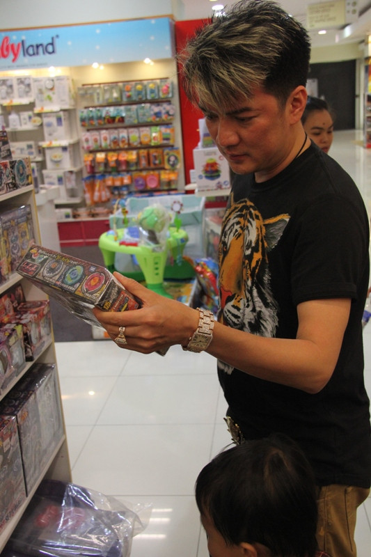 Mr Đàm khá kỹ tính trong việc chọn đồ chơi cho con....Dường như anh đang xem nguồn gốc của món đồ. Mr Đàm khá kỹ tính trong việc chọn đồ chơi cho con....Dường như anh đang xem nguồn gốc của món đồ.