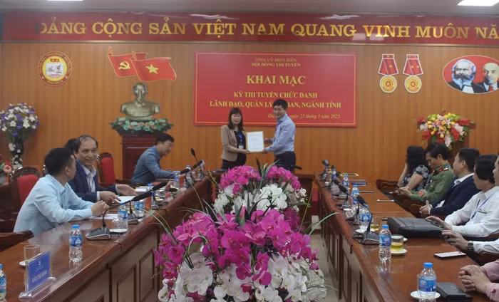 Sáng 23/3, tỉnh Điện Biên tổ chức khai mạc kỳ thi tuyển chức danh lãnh đạo, quản lý 3 sở, ngành, gồm: Sở Giáo dục và Đào tạo; Sở Lao động-Thương binh và Xã hội, Sở Tư pháp. Đồng chí Lê Thành Đô (bên phải), Chủ tịch Ủy ban nhân dân tỉnh, Phó Chủ tịch Hội đồng thi chuyển giao bộ đề thi cho Ban coi thi. Ảnh: Báo Nhân dân.