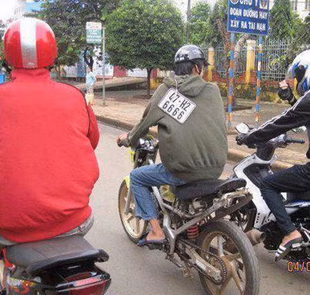 Xe không có chỗ đặt biển đành vác tạm lên vai. Xe không có chỗ đặt biển đành vác tạm lên vai.