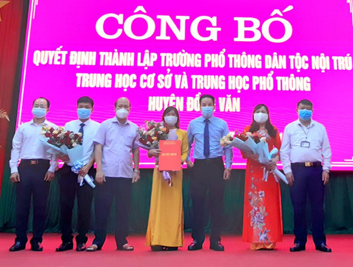 Lãnh đạo Sở Giáo dục và Đào tạo Hà Giang trao quyết định, tặng hoa Ban Giám hiệu Trường phổ thông dân tộc nội trú Trung học cơ sở và Trung học phổ thông Đồng Văn. Ảnh: nhà trường cung cấp