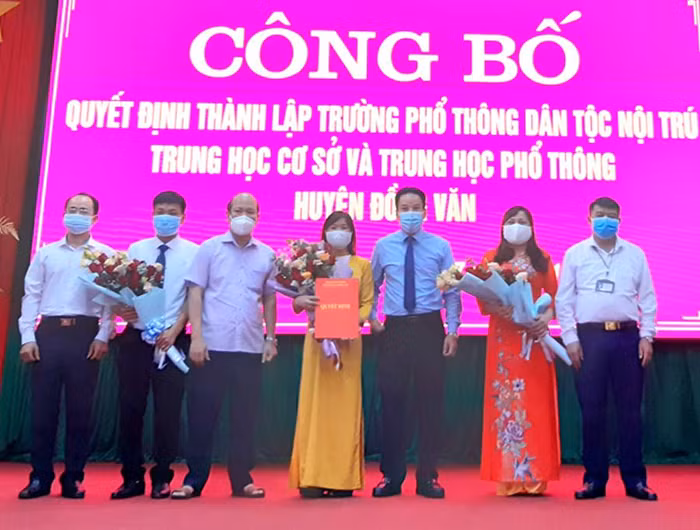 Lãnh đạo Sở Giáo dục và Đào tạo Hà Giang trao quyết định, tặng hoa Ban Giám hiệu Trường phổ thông dân tộc nội trú Trung học cơ sở và Trung học phổ thông Đồng Văn. Ảnh: nhà trường cung cấp