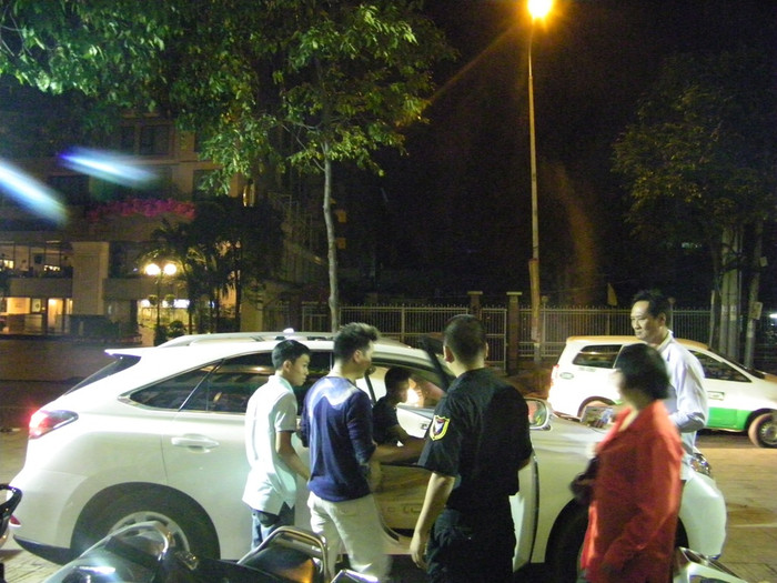 Mr Đàm bước thật nhanh ra xe, trong sự bảo vệ của một vệ sĩ và hai trợ lý (bìa phải và trái).