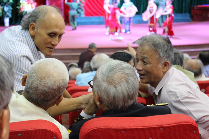 Nhiều người đã lãng tai, hỏi thăm nhau phải ghé tai sát lại. (Ảnh: Lại Cường)