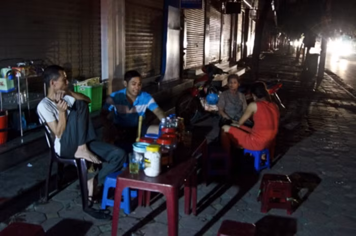 Nóng bức nhưng đến nửa đêm, nhiều người vẫn ngồi tập trung ở vỉa hè đường Tô Hiệu để tránh nóng. Ảnh: Nguyên Anh