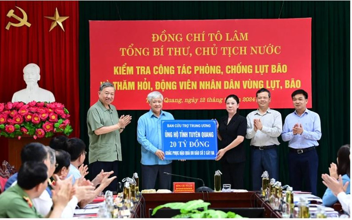 Tổng Bí thư, Chủ tịch nước Tô Lâm chứng kiến đồng chí Đỗ Văn Chiến, Ủy viên Bộ Chính trị, Bí thư Trung ương Đảng, Chủ tịch Ủy ban Trung ương Mặt trận Tổ quốc Việt Nam trao biển ủng hộ số tiền 20 tỷ đồng cho lãnh đạo tỉnh Tuyên Quang. Capture.JPG