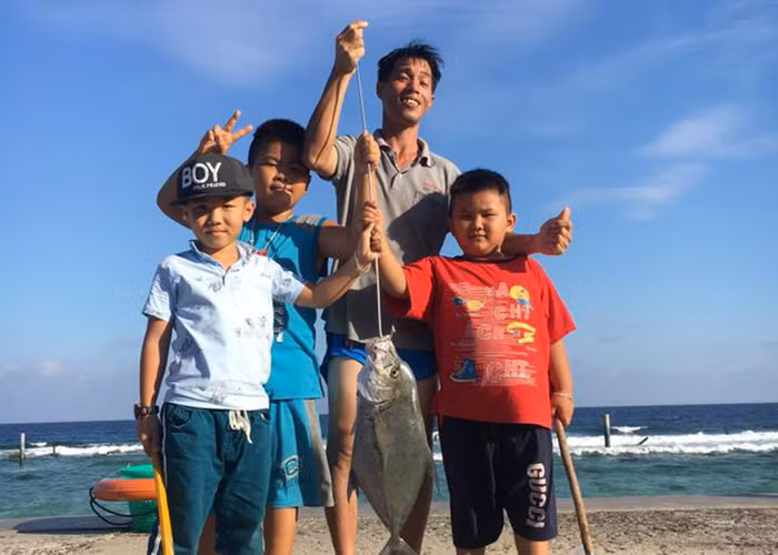 Thầy Nguyễn Hữu Phú và các em học sinh trong một lần câu cá. (Ảnh: H.P)