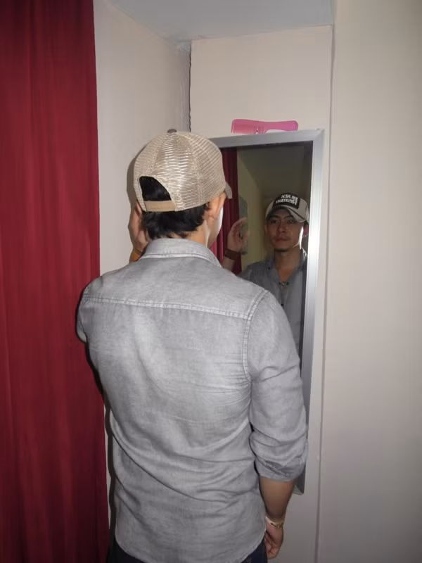 Võ Trọng Phúc đứng trước gương, chỉnh lại trang phục.