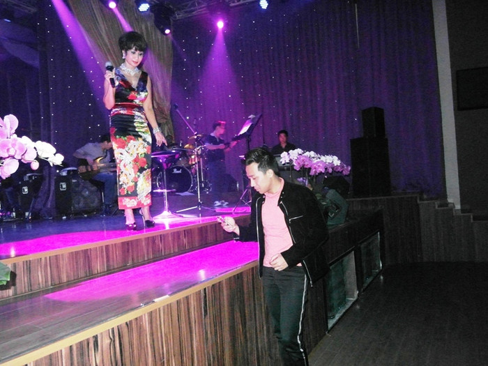 Trấn Thành bước lên, nhanh nhẩu, cứu nguy ngay cho danh ca, lục tìm trong điện thoại lời hai ca khúc khán giả yêu cầu.