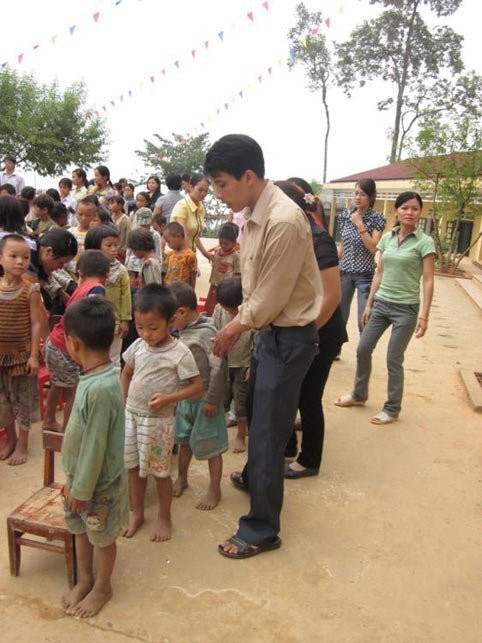 Các thầy cô đang hướng dẫn các em tập trung chào cờ.