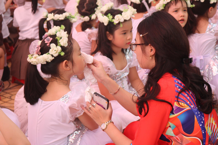 Trước bắt đầu năm học mới và sẻ chia các kiến thức với học sinh, các cô dành sự quan tâm, chăm sóc cho các con đầu cấp bằng những hành động đẹp. Cô giáo lau mồ hôi cho các thiên thần nhỏ trong thời gian chờ lên sân khấu biểu diễn văn nghệ. Ảnh: Đỗ Thơm