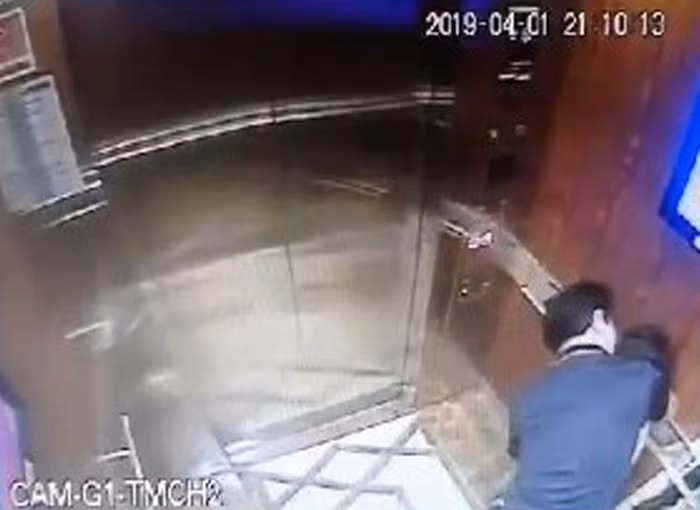 Hình ảnh người đàn ông ôm ấp bé gái trong thang máy qua màn hình camera. (Ảnh cắt từ clip)