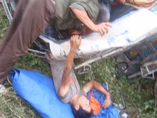 Một nạn nhân bị thương nặng ở chân được lực lượng cứu hộ đưa ra khỏi cabin xe . Ảnh: N.Phê.