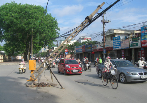 Cột điện đổ gây nguy hiểm cho người đi đường, chụp sáng 9/5/2012 trên đường Trường Chinh (Hà Nội). Ảnh: Lê Hội. Cột điện đổ gây nguy hiểm cho người đi đường, chụp sáng 9/5/2012 trên đường Trường Chinh (Hà Nội). Ảnh: Lê Hội.