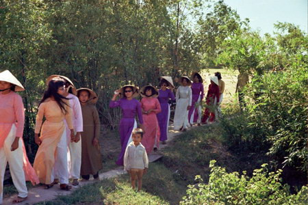 Cô dâu là người mặc áo hồng, đi giữa hai phụ nữ mặc áo dài tím.