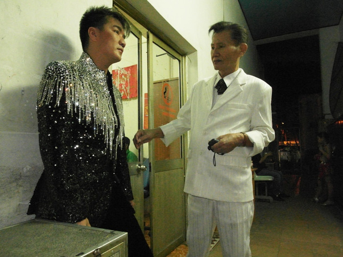 "Bầu sô" lão thành Duy Ngọc đến chỉnh sửa áo cho Đàm Vĩnh Hưng trước giờ anh bước ra sân khấu.