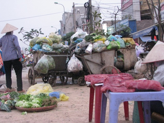 Những phản thịt được bày bán chềnh ềnh chung với rác thải. Người dân vẫn thờ ơ, bỏ mặc vì miếng cơm manh áo để mưu sinh.