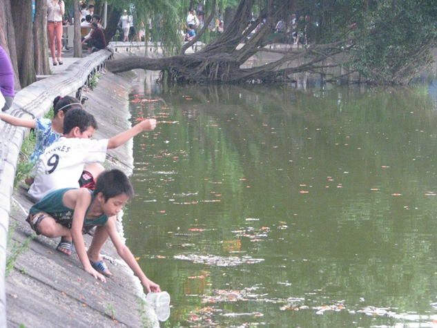 rẻ em “liều mình” cố nhoài người bất chấp sự rình rập tử thần.