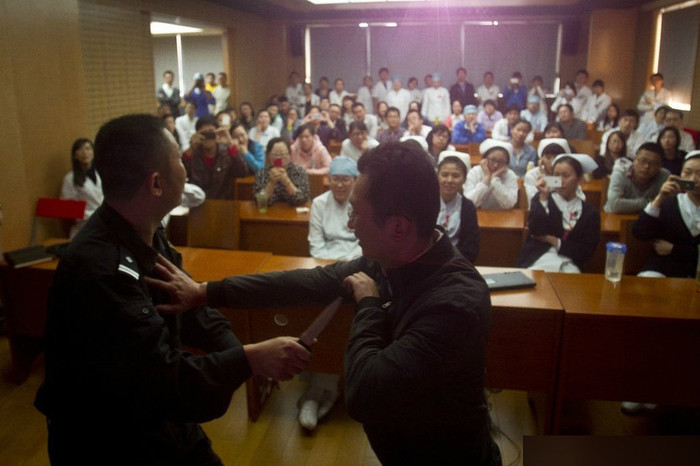 Cảnh sát giới thiệu cách đối phó với tình huống bị tấn công, các bác sĩ, y tá chăm chú theo dõi.