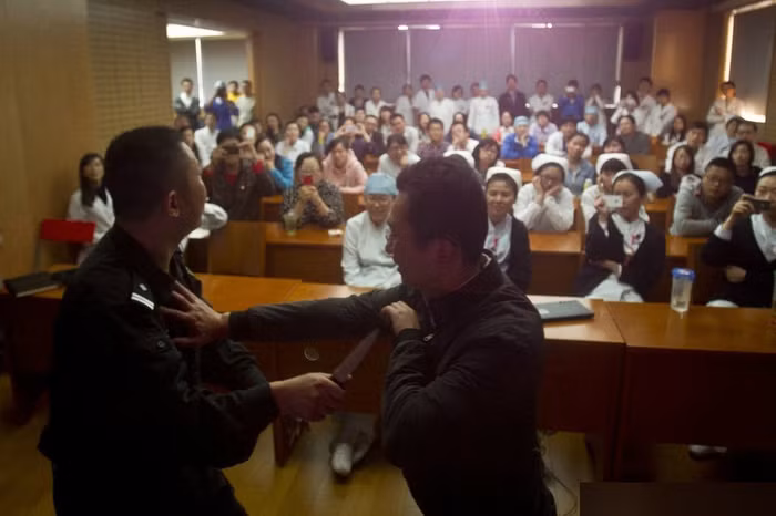 Cảnh sát giới thiệu cách đối phó với tình huống bị tấn công, các bác sĩ, y tá chăm chú theo dõi.