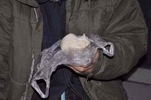 Ông lão ngoài trăm tuổi móm mém nhai chiếc bánh bao lót dạ