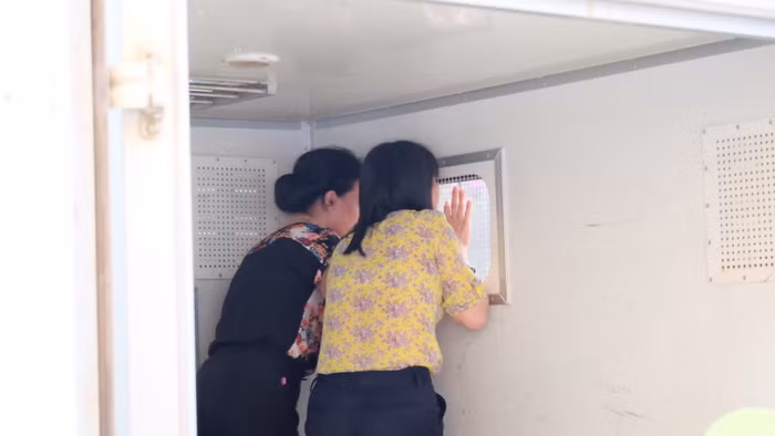 Hai bị cáo Liên và Loan gọi người thân sau cánh xe tù.