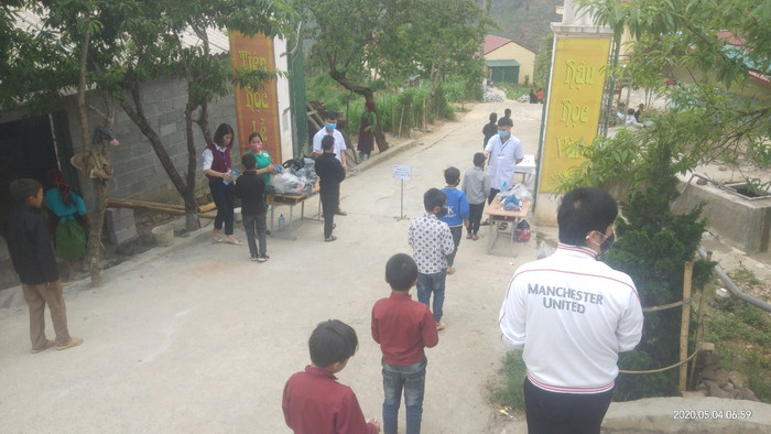 Học sinh trường Sảng Tủng đứng giãn cách để kiểm tra y tê.