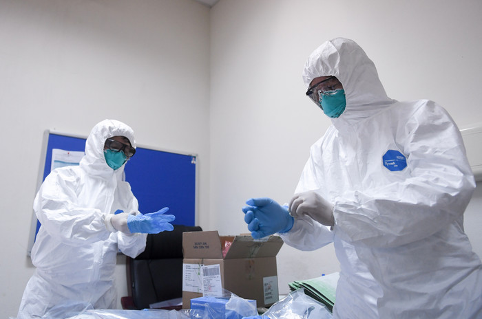 Trước khi vào tiếp xúc người bệnh, những người trong đoàn đã mặc đồ bảo hộ cẩn thận và đeo 2 lớp găng tay để đảm bảo an toàn.