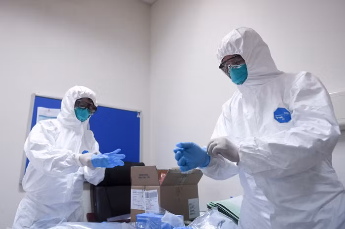 Trước khi vào tiếp xúc người bệnh, những người trong đoàn đã mặc đồ bảo hộ cẩn thận và đeo 2 lớp găng tay để đảm bảo an toàn.