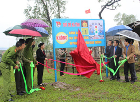 Lãnh đạo tỉnh Hà Tĩnh và đoàn viên thanh niên gắn pa nô tuyên truyền an toàn giao thông - Ảnh: Chu Hoài