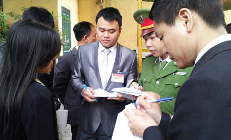 Cơ quan chức năng kiểm tra danh sách những người được vào khu vực xét xử - Ảnh: Hà An/Thanh Niên