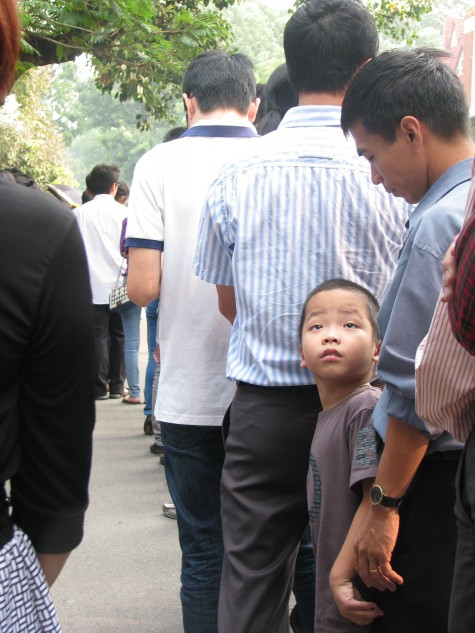 Len lỏi trong đoàn người là hình ảnh một cậu bé đến xếp hàng từ rất sớm.