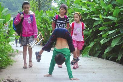 Nhan Ngọc Hoành trồng chuối ngược để "đi" đến trường học. Nhan Ngọc Hoành trồng chuối ngược để "đi" đến trường học.