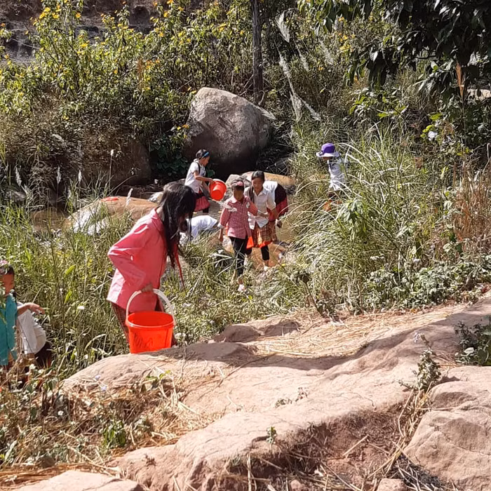 Sau giờ học, học sinh ở Na Cô Sa phải đi tìm đến những khe nước ở tận trong những khe đá sâu trong núi. Ảnh: LC