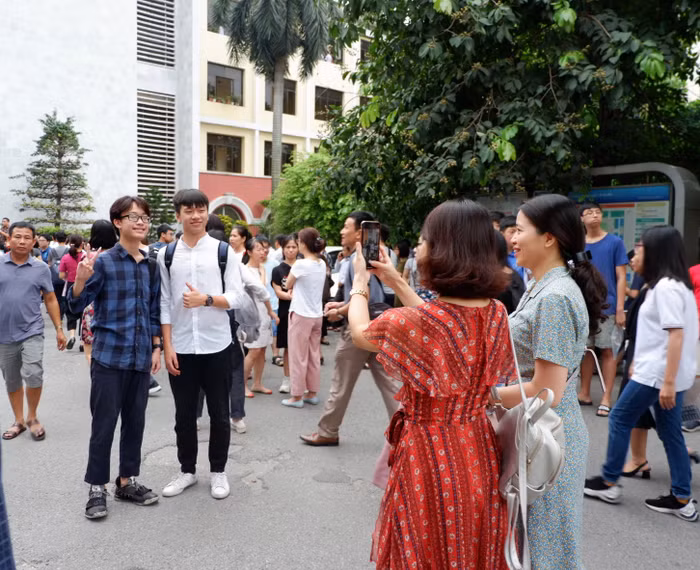Kỳ thi dù căng thẳng nhưng các phụ huynh và thí sinh vẫn muốn lưu lại kỷ niệm khi tới ngôi trường. Ảnh: Nguyễn Huyền