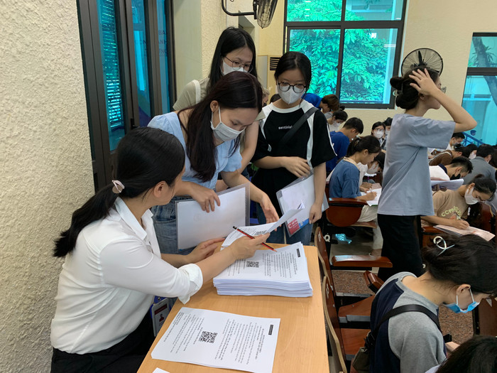 Sinh viên được nhân viên ngân hàng giao cho 1 tập giấy tờ về điền thông tin và nộp lại nhà trường sau. Ảnh: LC